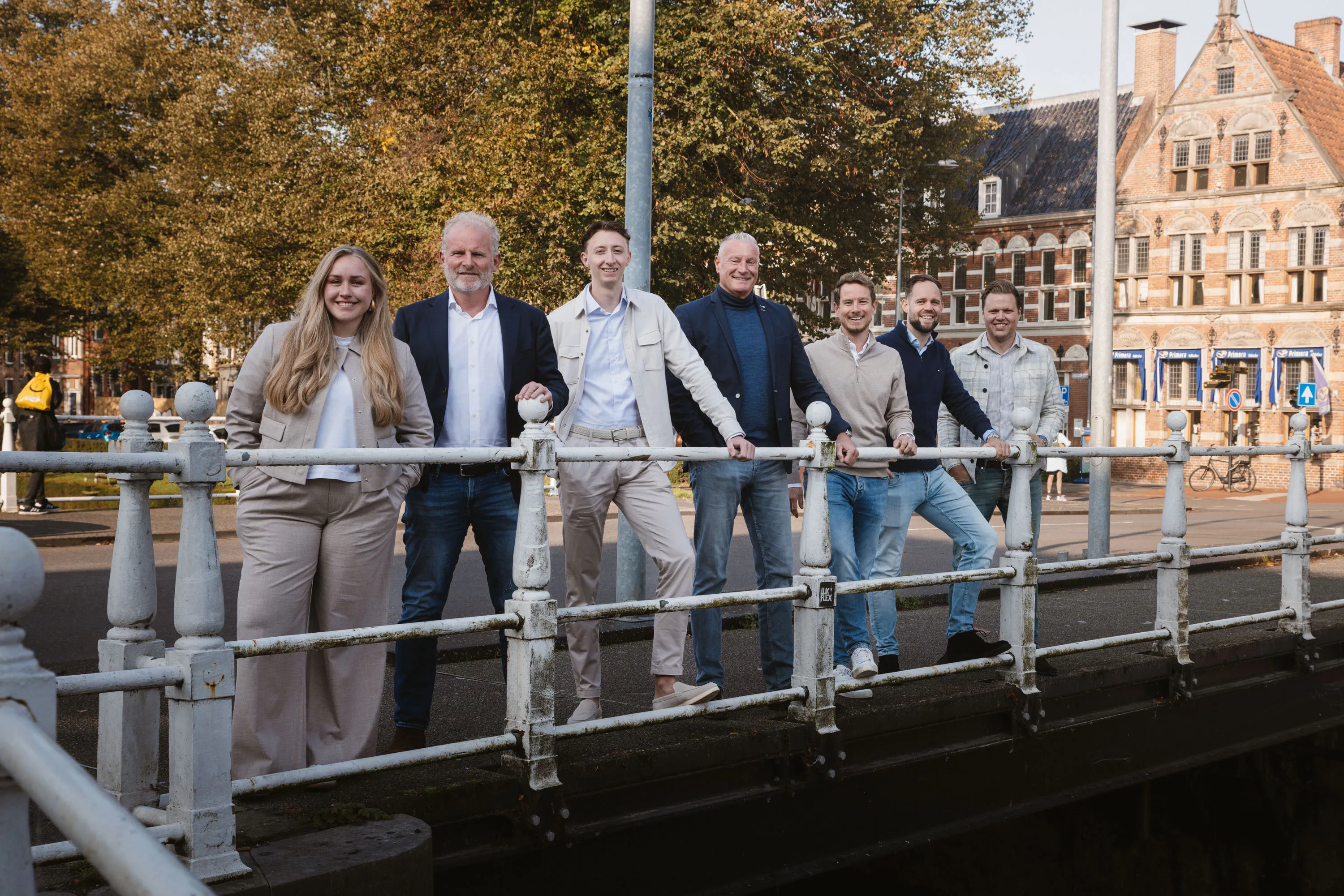 Het voltallige team van Tijssen & Vos op een brug in de Groningse binnenstad